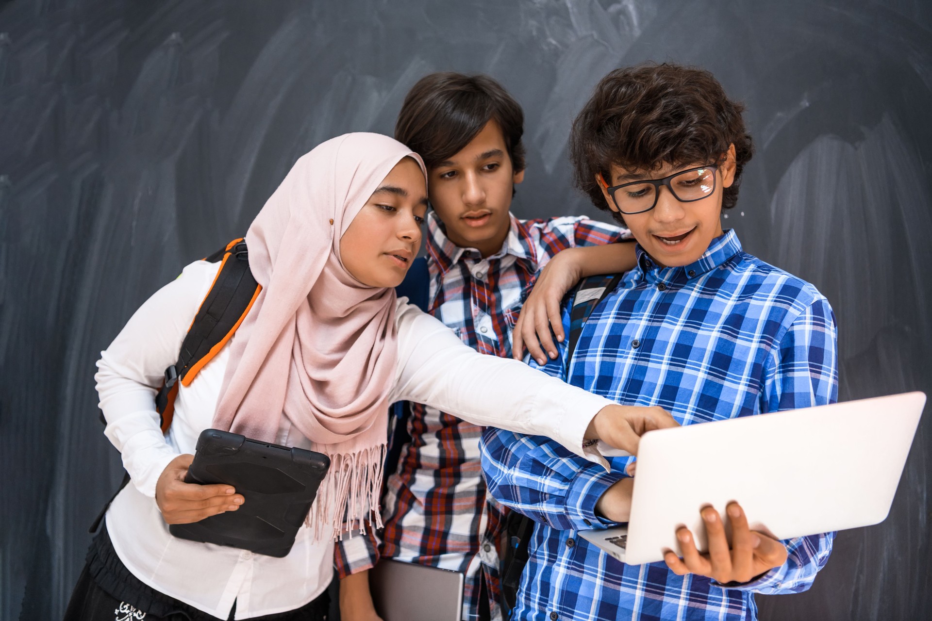 Arabic teenagers team, students group working together on laptop and tablet computer online classroom education concept